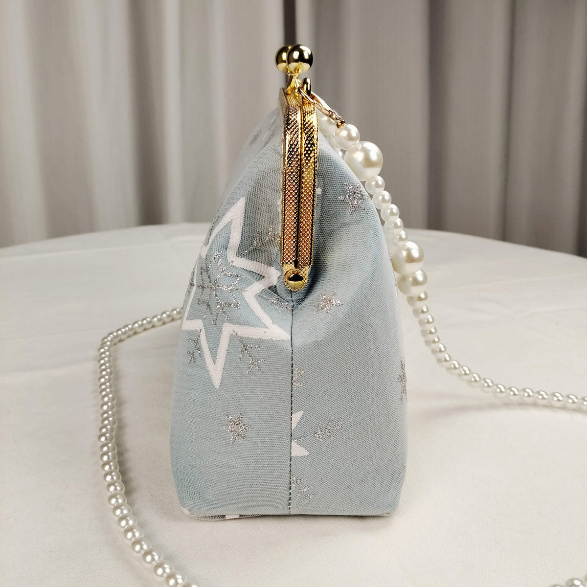 Side view of Acever A002 snowflake clutch bag showing gold zipper side detail powder blue polyester gusset and pearl bead strap connector