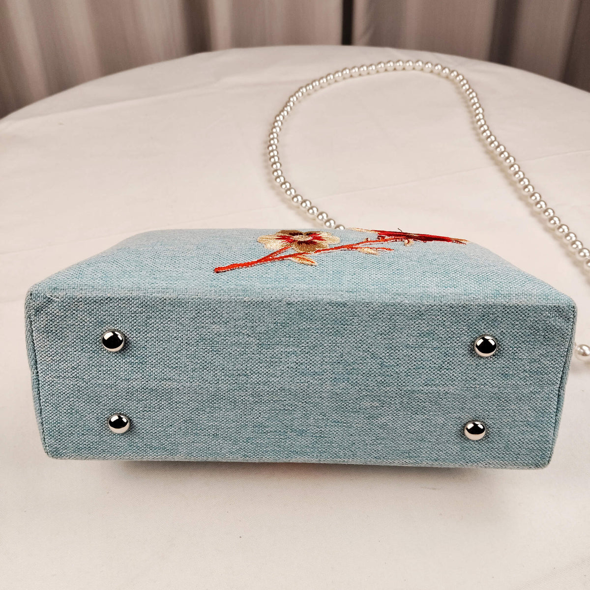 Bottom view of Acever A003 cherry blossom clutch bag showing powder blue polyester base and structured gusset