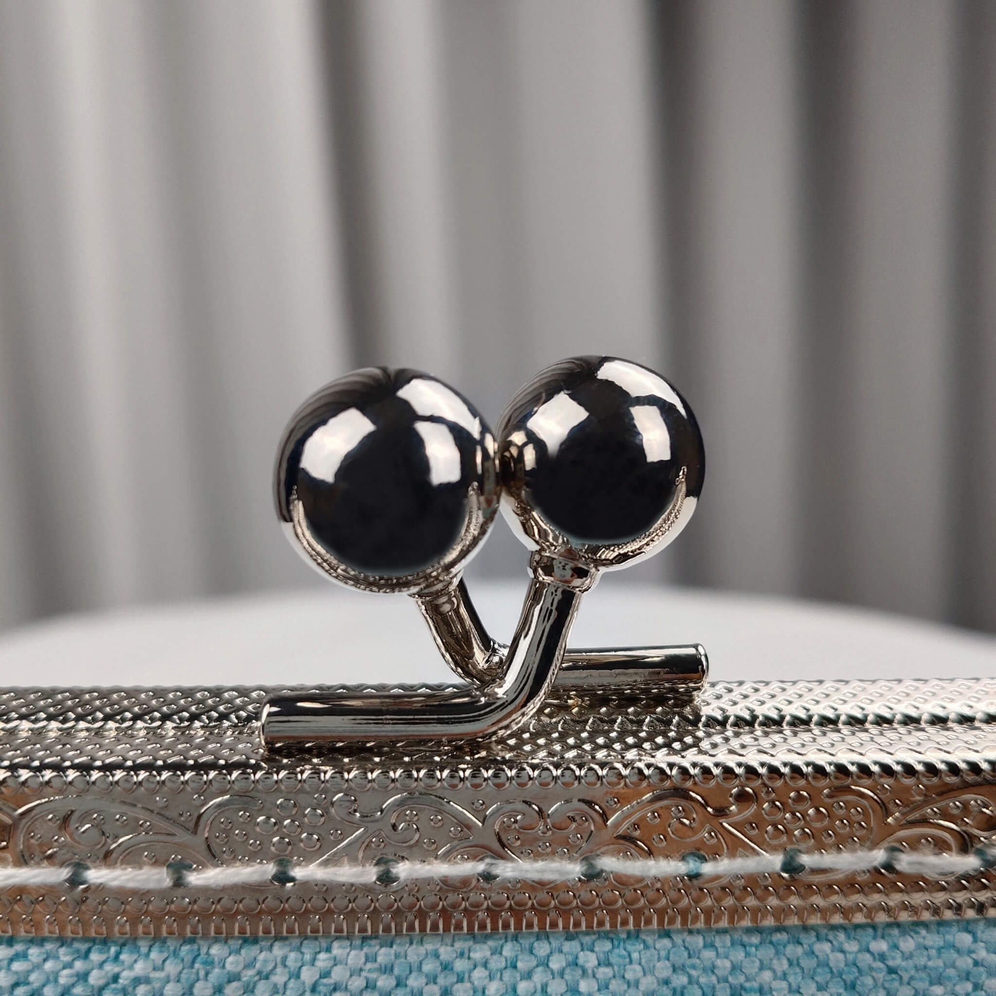 Close-up detail of Acever A003 clutch bag showing silver ornate filigree kiss-lock frame with twin ball clasp and silver lobster clasp pearl strap connector