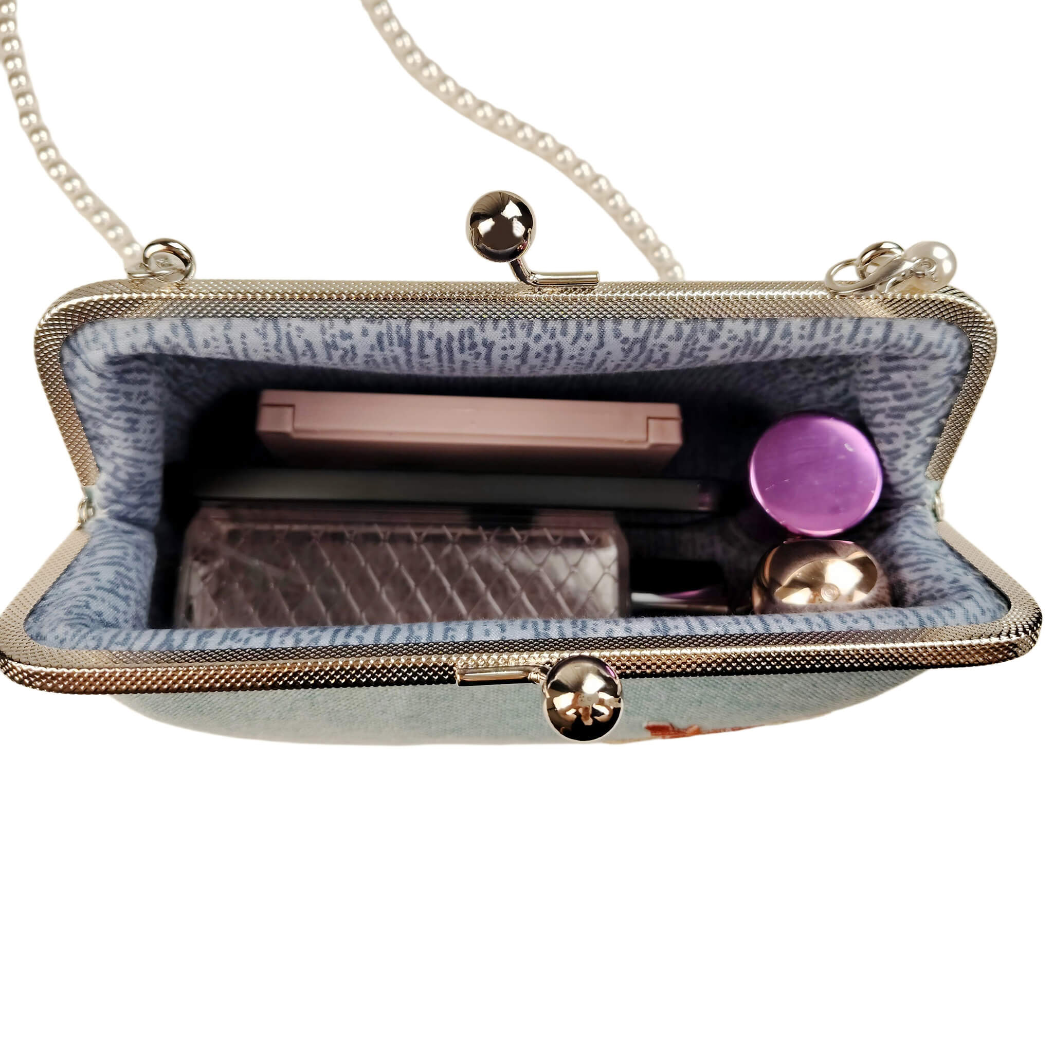 Acever A003 cherry blossom clutch bag lifestyle shot on white table beside green ceramic vase with yellow sunflowers showing full bag front view with silver kiss-lock frame and pearl bead strap