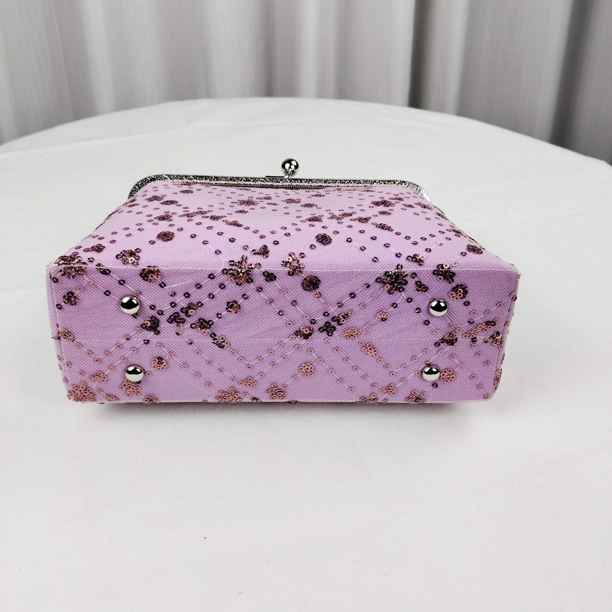 Bottom view of Acever A005 sequin floral quilted clutch bag showing lavender polyester base with diamond quilting and scattered sequin dot accents