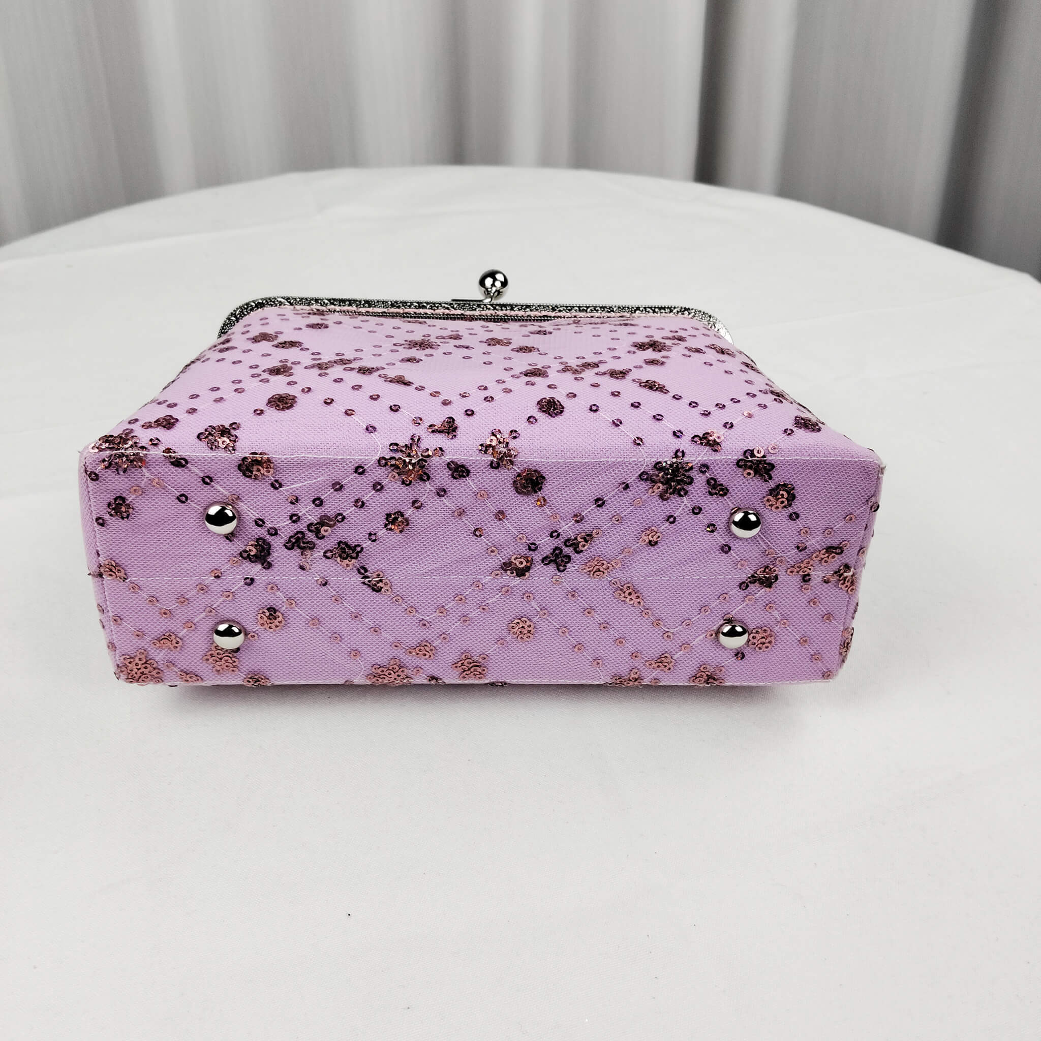 Bottom view of Acever A005 sequin floral quilted clutch bag showing lavender polyester base with diamond quilting and scattered sequin dot accents