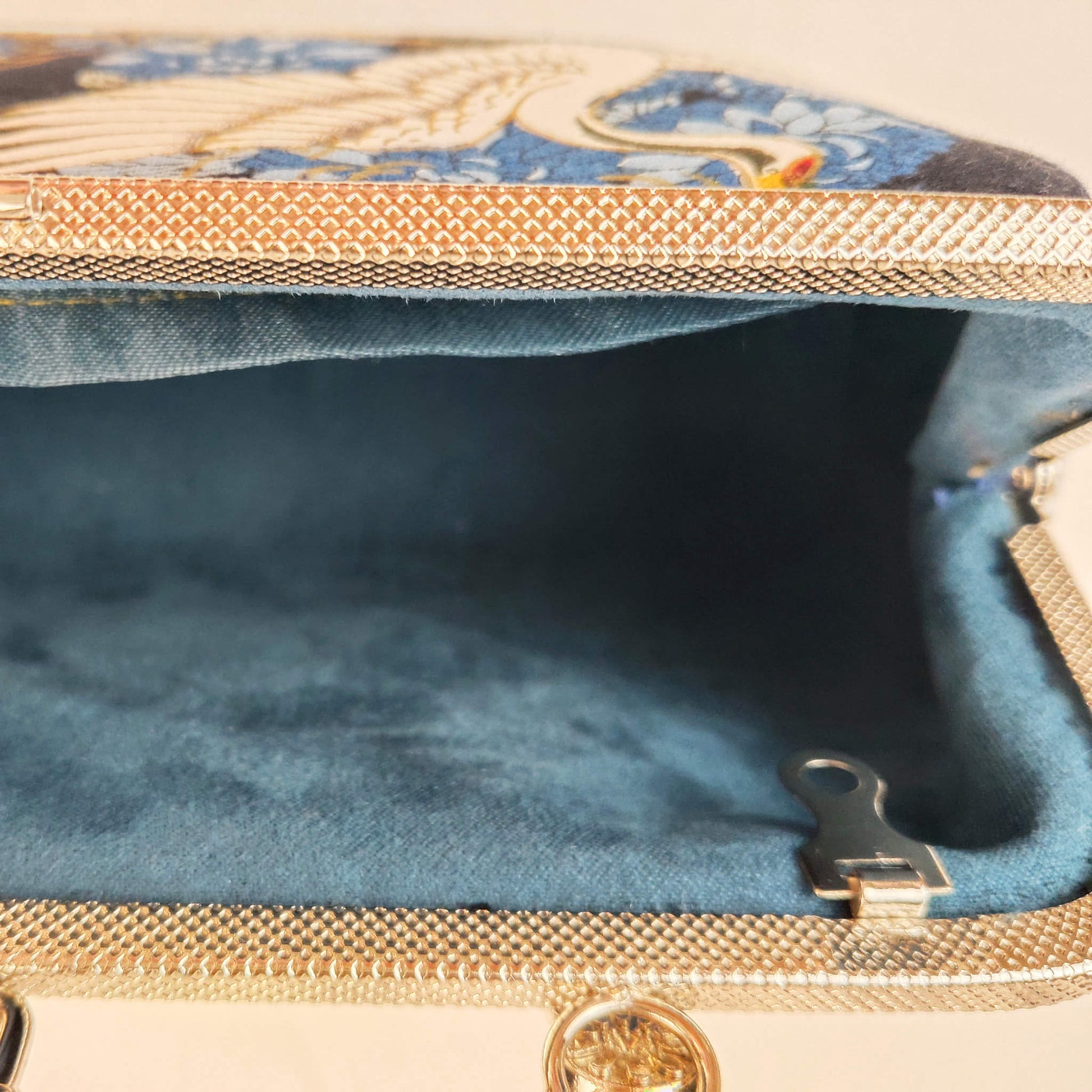Close-up detail of Acever A006 bag showing white crane with gold-outlined feathers and blue peony chrysanthemum print on midnight navy polyester fabric