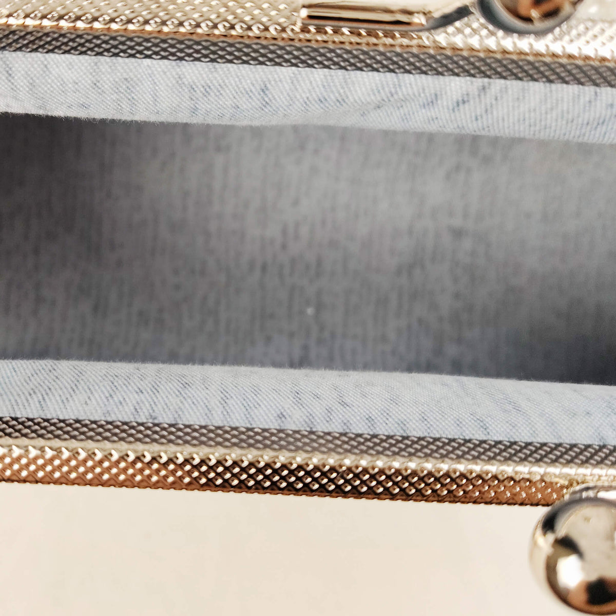 Close-up detail of Acever B001 clutch bag showing silver glitter snowflake embroidery of varying sizes and tiny silver star dot accents on sheer tulle overlay over ice blue polyester fabric