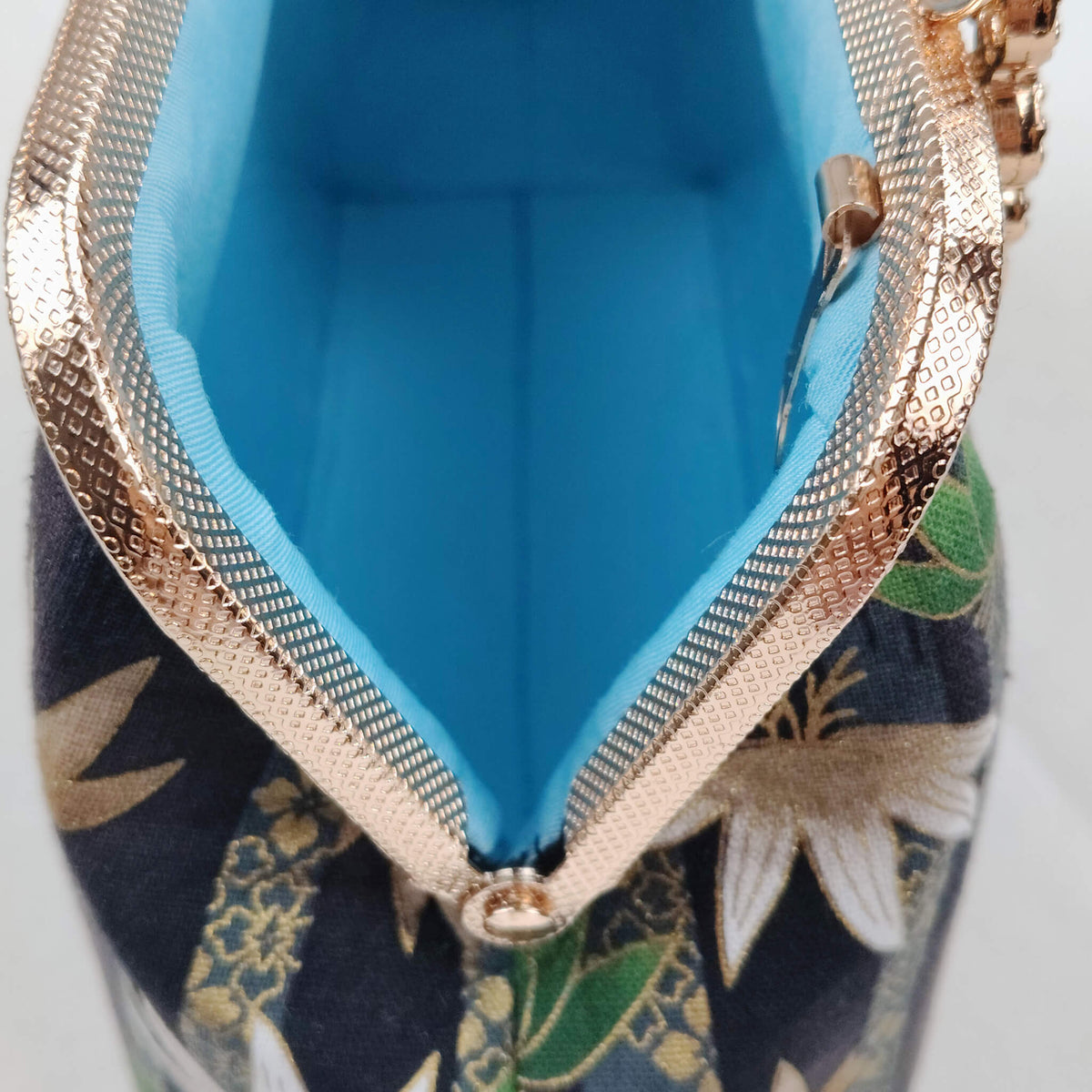 Interior view of Acever B002 lotus and leaf jacquard bag open showing bright turquoise blue smooth fabric lining with single open compartment and rose gold frame edge