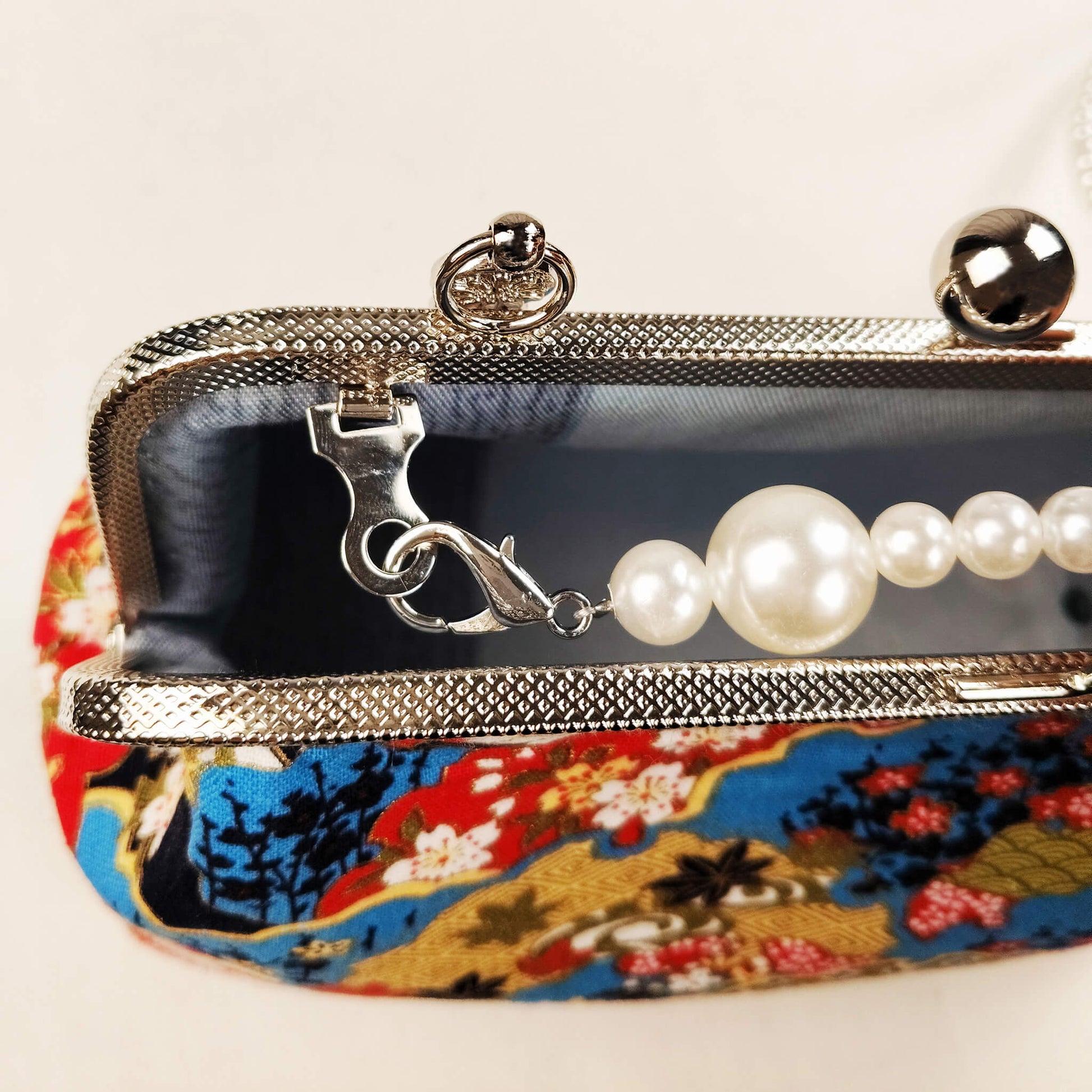 Close-up detail of Acever B003 bag showing antique silver textured zipper side detail and silver lobster clasp connector with pearl bead strap on Japanese Nishiki brocade fabric