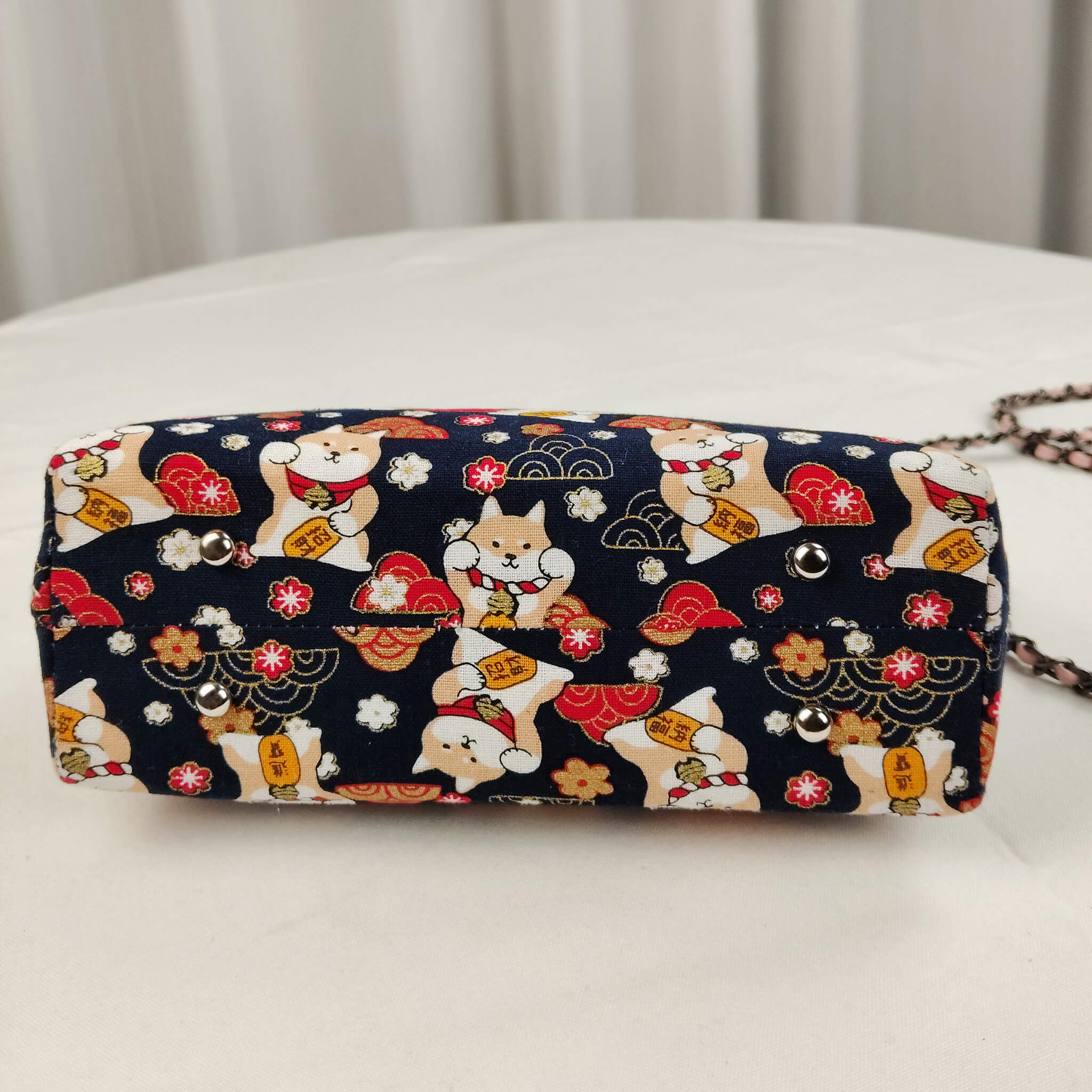 Bottom view of Acever B005 Lucky Shiba Inu top handle bag showing midnight navy polyester base with all-over Shiba Inu dogs red clouds golden wave fans and cherry blossom print