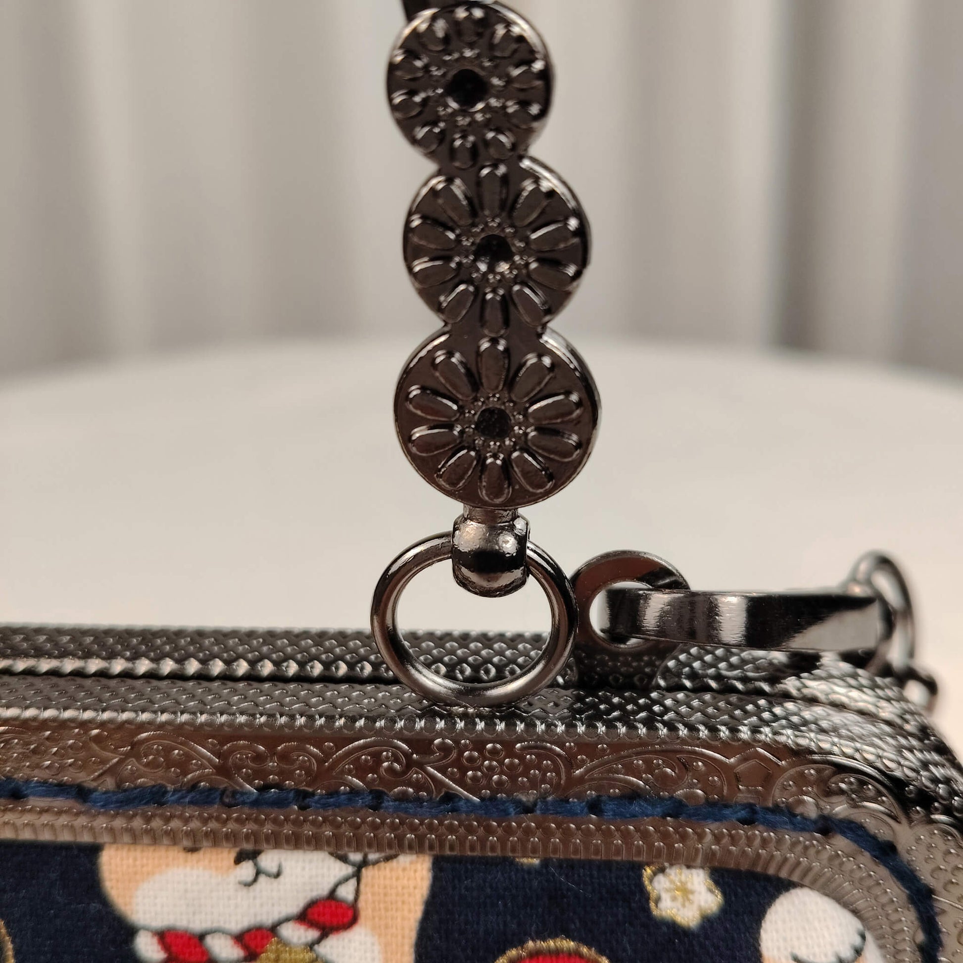 Close-up detail of Acever B005 bag showing cream tan Shiba Inu dog in lucky maneki-neko pose holding gold coin pouch with Chinese character banner surrounded by red auspicious clouds and golden seigaiha wave fans on midnight navy polyester fabric