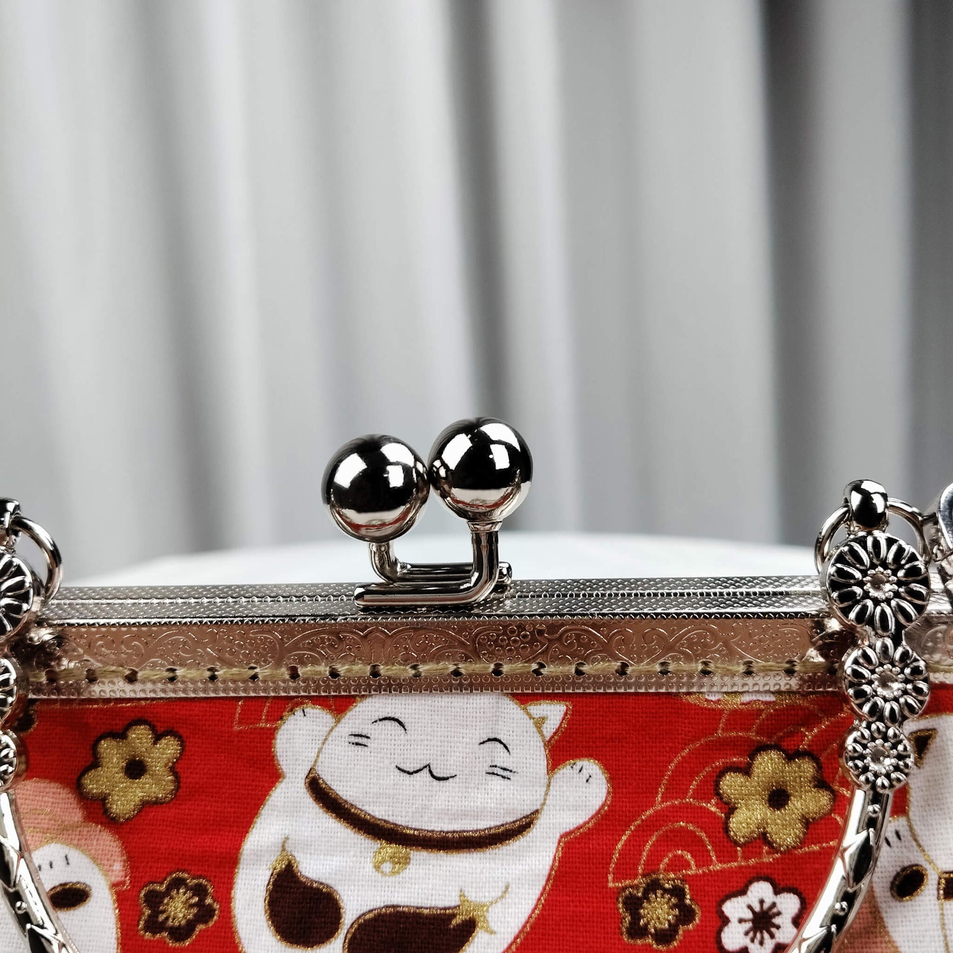 Close-up detail of Acever B006 bag showing gunmetal ornate engraved kiss-lock frame with double twin ball clasp decorative top handle with triple floral medallion connectors and gunmetal flat-link chain crossbody strap with lobster clasp