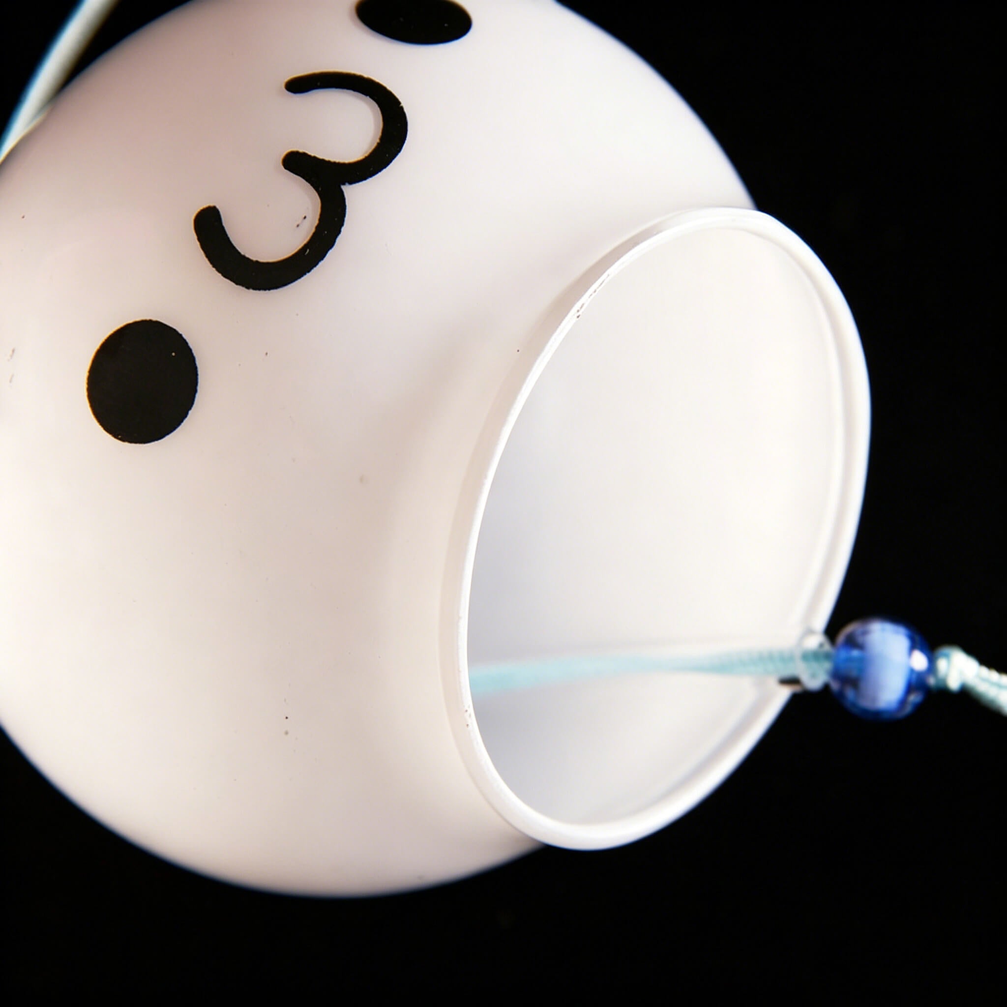 Bottom view of Acever kawaii face glass wind chime X03 showing white globe with laughing expression and kawaii character paper strip