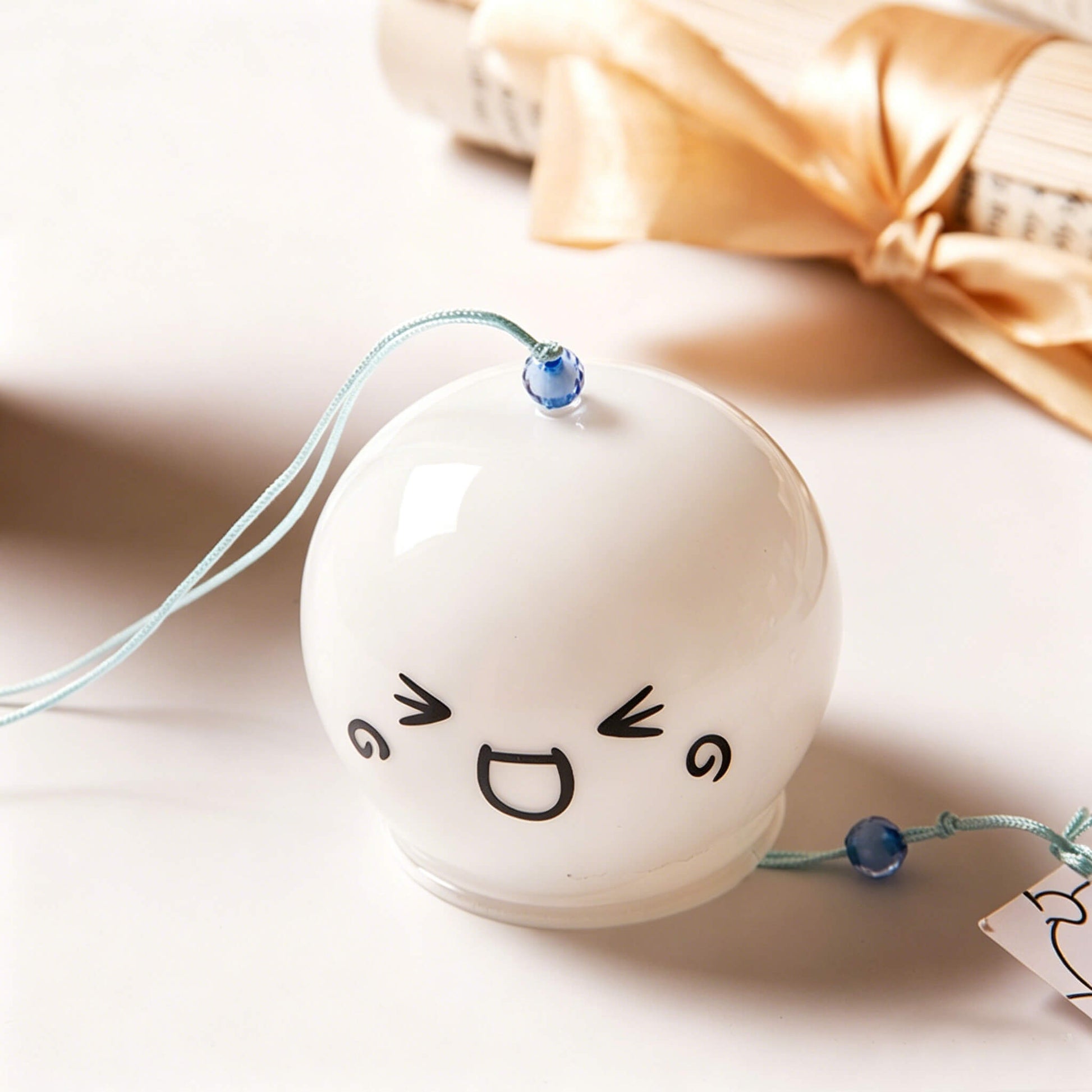 Top view of Acever kawaii face glass wind chime X03 with blue bead and teal hanging cord