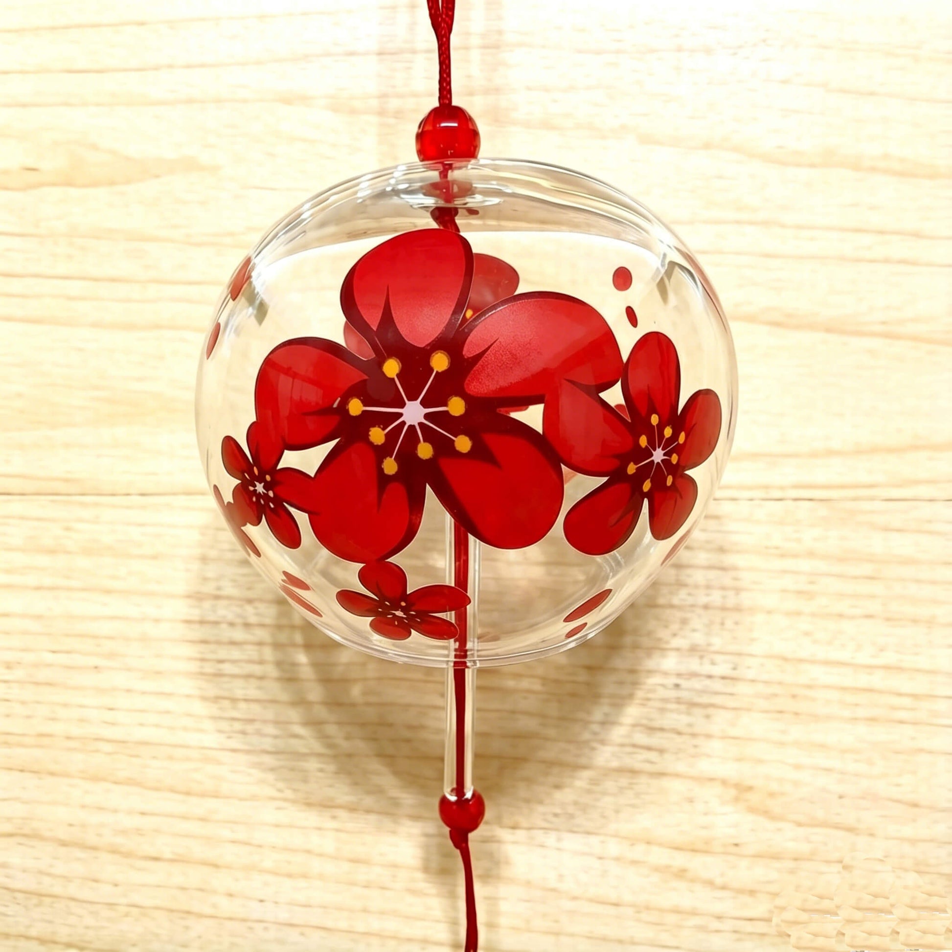 Detail shot of Acever red sakura glass wind chime X05 showing flat-edge clear globe with bold red cherry blossom pattern and pink paper strip