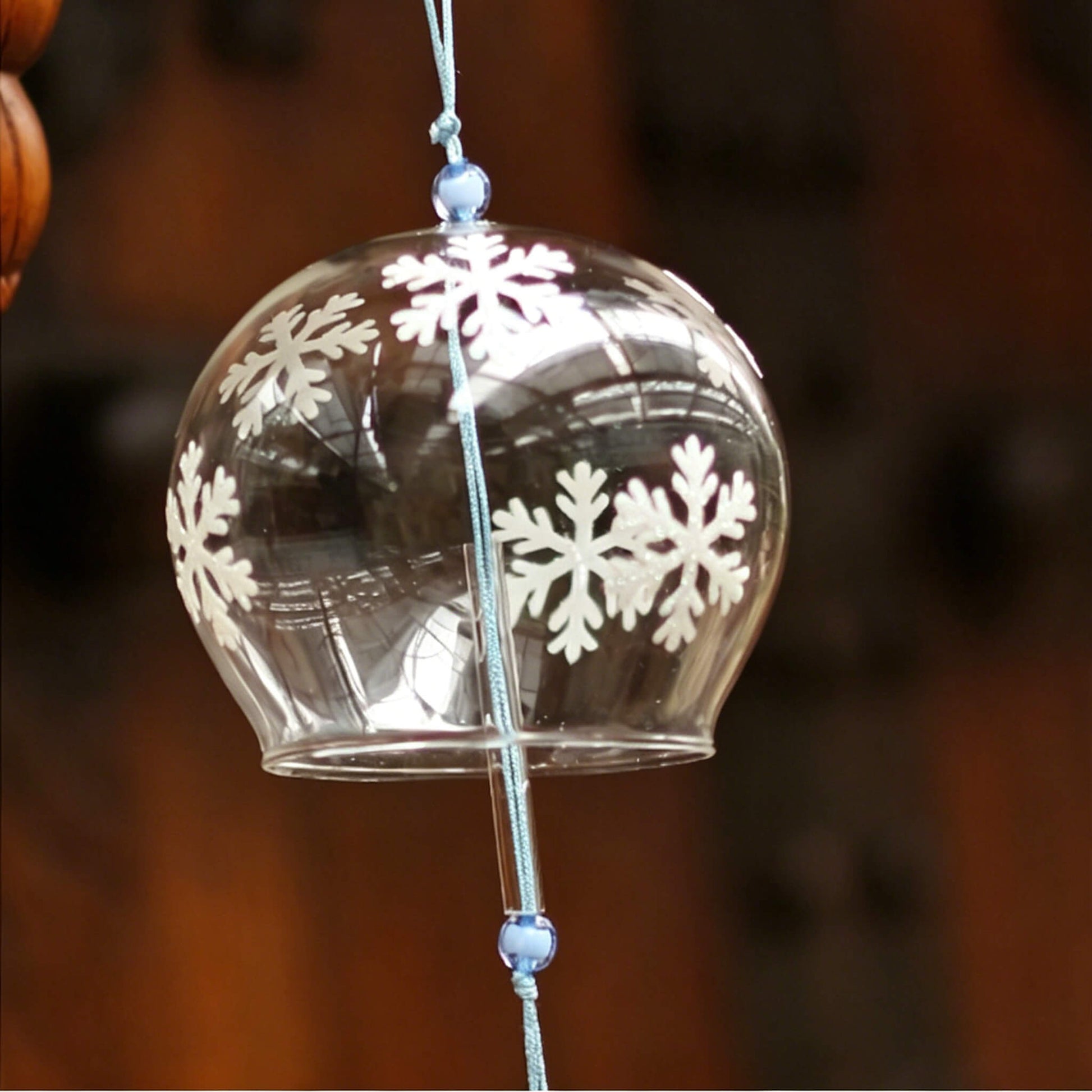 Acever white snowflake glass wind chime X07 hanging against traditional wooden architecture showing the detail of snowflake