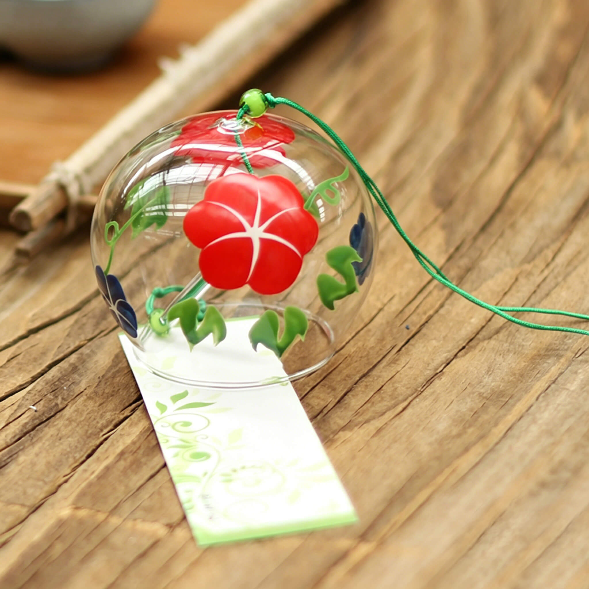 Close-up of Acever morning glory glass wind chime X11 showing red asagao blossom and green vines on clear flat-rim globe with green cord