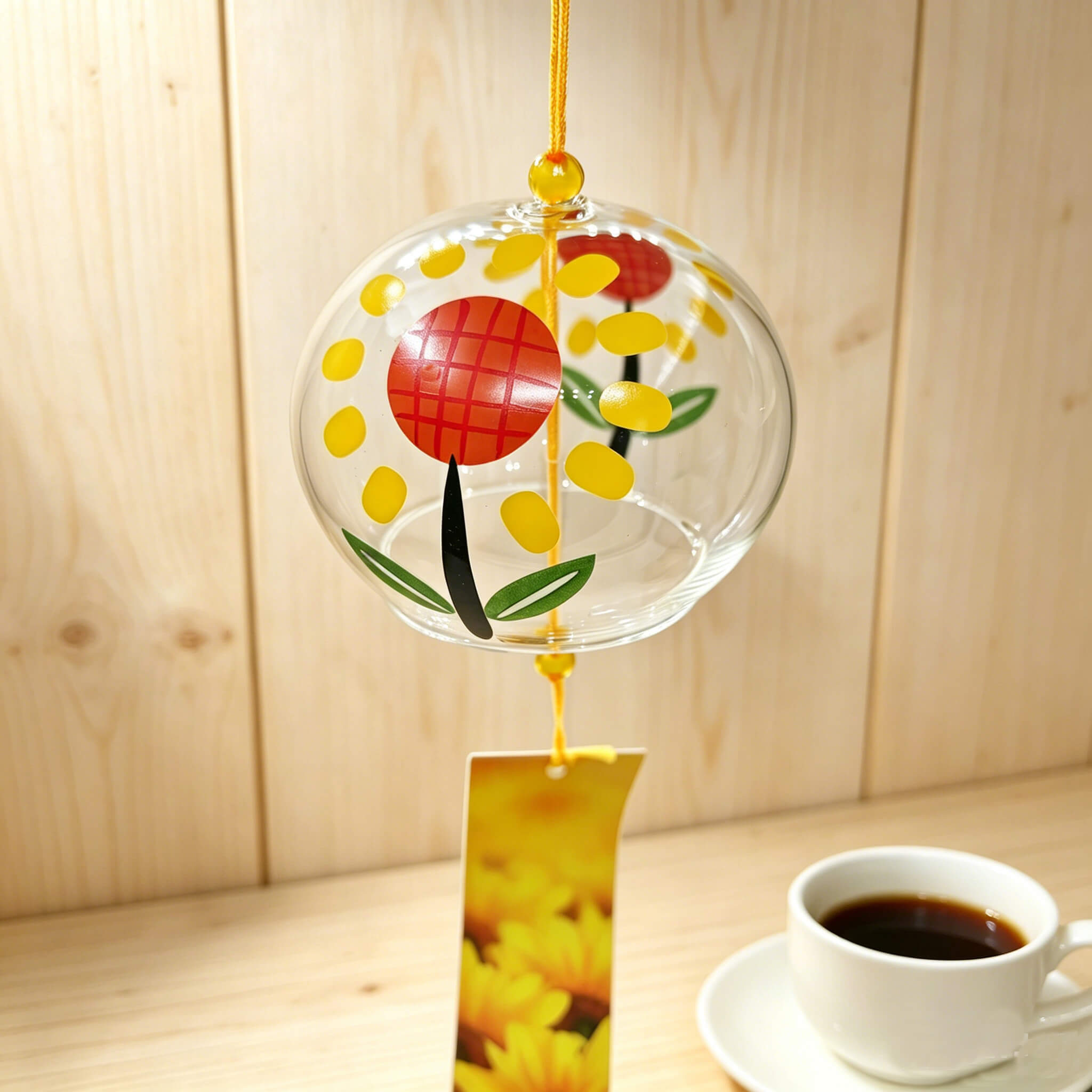 Close-up of Acever sunflower glass wind chime X13 showing bold sunflower with red crosshatch center and golden petals on clear flat-rim globe