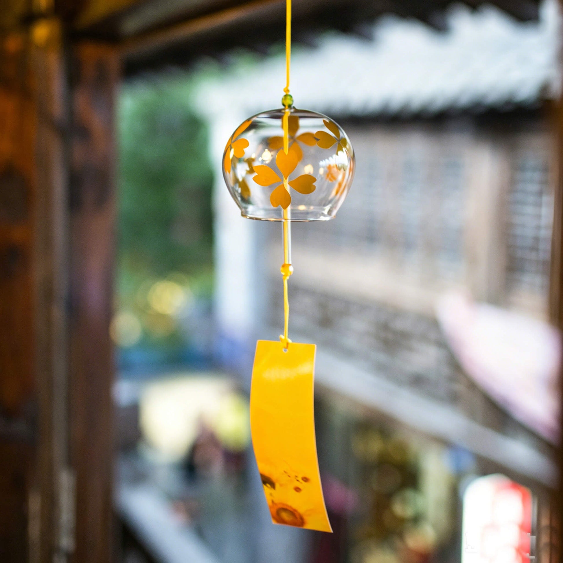 Acever golden heart-petal flower glass wind chime X15 hanging under bougainvillea arch against blue sky with golden sunflower paper strip swaying