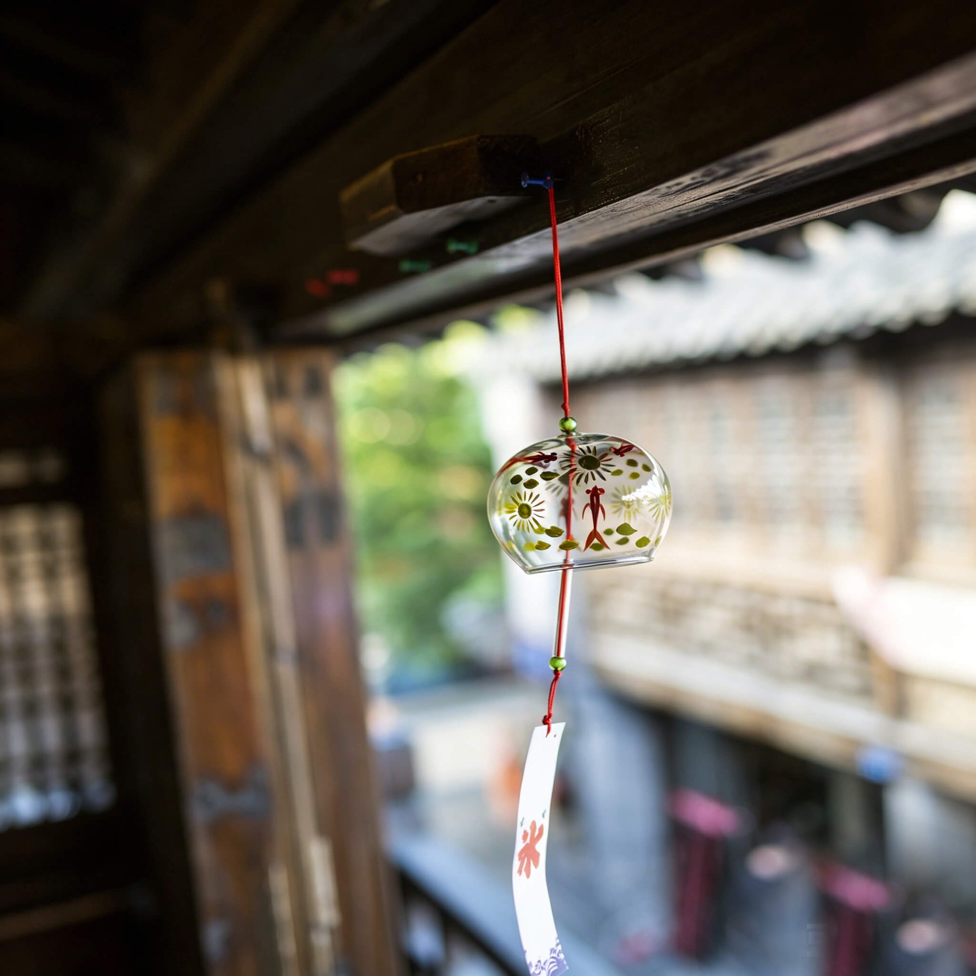 Acever red goldfish glass wind chime X27 hanging from traditional Japanese wooden eave corridor showing clear globe with kingyo design and white goldfish paper strip