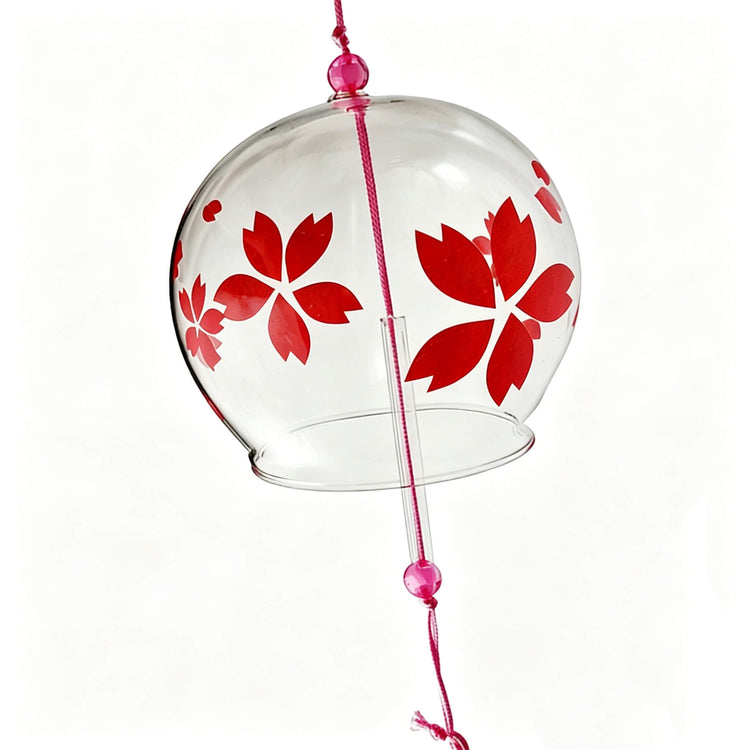 Close-up of Acever red sakura glass wind chime X37 on white background showing clear globe with large red sakura bloom and scattered petals with pink cord and pink glass beads