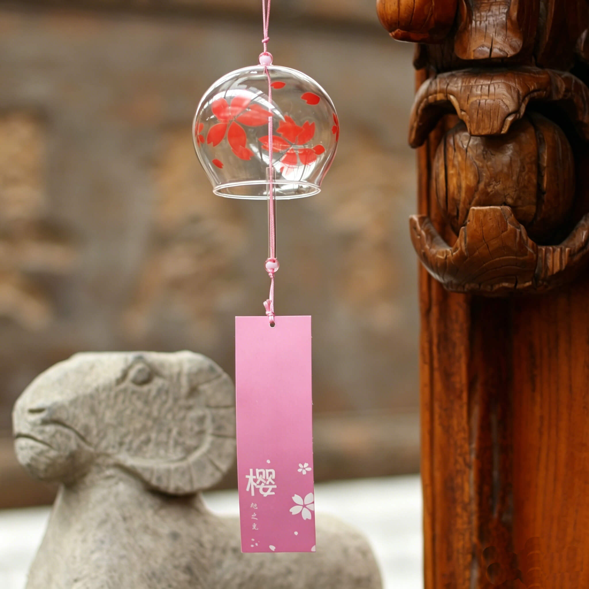 Acever red sakura glass wind chime X37 hanging from traditional Japanese wooden eave showing clear globe with red sakura blooms and dark burgundy paper strip with sakura kanji